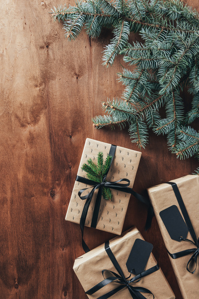 flat lay with christmas presents, fir branches and tags on wooden background with copy space - Фото, зображення