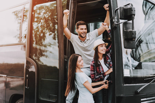 Young Smiling People Traveling on Tourist Bus. Group of Happy Friends Standing Together in Doors of Tour Bus. Traveling, Tourism and People Concept. Happy Travelers on Trip. Summer Vacation - Photo, Image