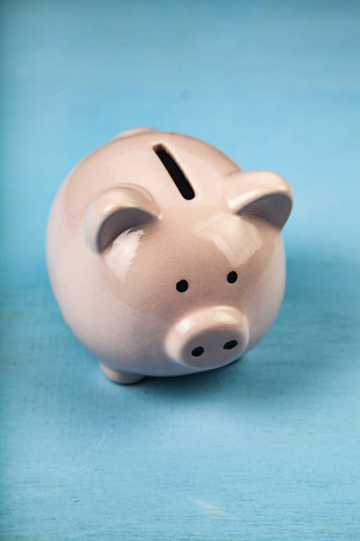 Pink pig money box on blue wooden background close up. - Foto, Imagem