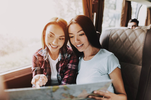 Young Beautiful Smiling Women Holding Paper Map. Casualy dressed Happy Travelers Planning Route Together by Looking at Map. Traveling, Tourism and Friendship Concept. Summer Vacation - Photo, Image