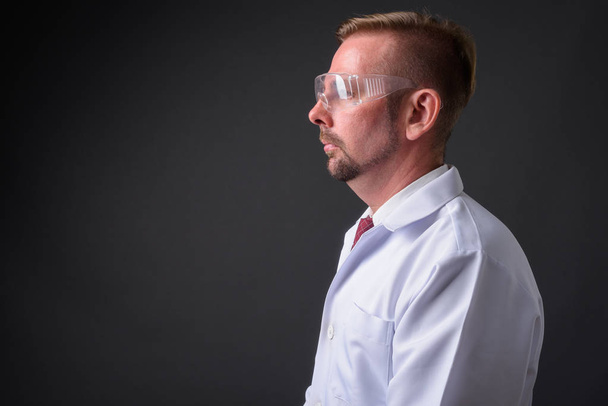 Blond vousatý muž lékař s bradkou proti šedému pozadí - Fotografie, Obrázek
