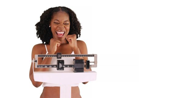 attraente nero donna felicemente pesa se stessa su scala in studio con copyspace
 - Foto, immagini