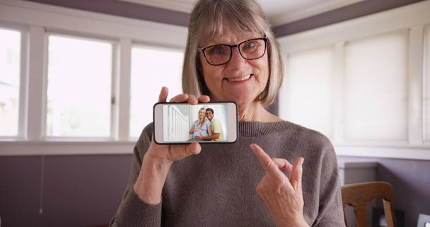 charmante alte Frau zeigt Video von schwangerer Tochter mit Ehemann am Telefon - Foto, Bild