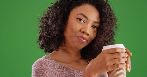 Charming African American woman with coffee cup posing on green screen - Foto, immagini