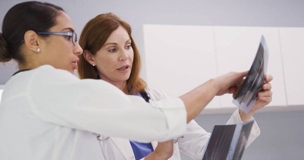 Due colleghi medici che guardano le radiografie dei pazienti polso e mano dentro ufficio
 - Foto, immagini