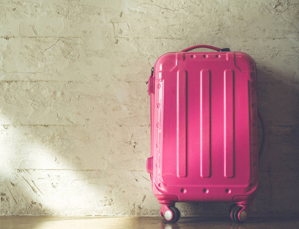 レンガ壁の比較でピンクのスーツケース - 写真・画像