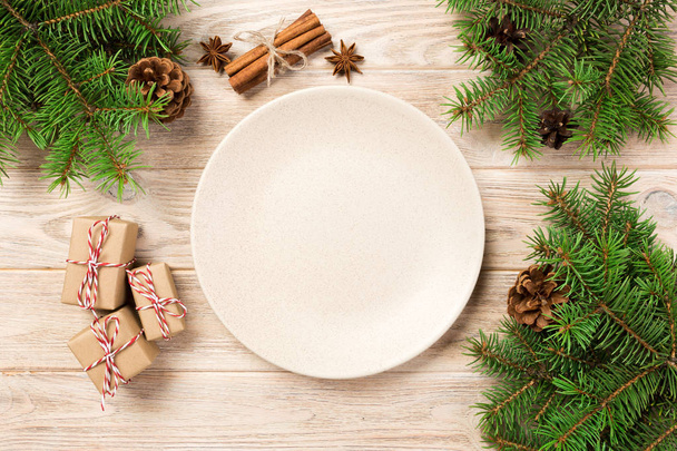 Lege witte matte plaat op houten achtergrond. met de decoratie van Kerstmis, ronde schotel. Nieuwjaar concept. - Foto, afbeelding