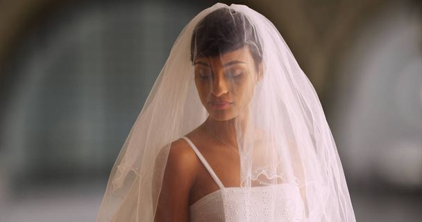 Porträt einer errötenden Braut in Brautkleid und Schleier - Foto, Bild