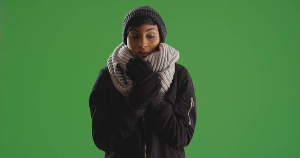 Portrait of shivering black female in winter attire on green screen - Photo, Image
