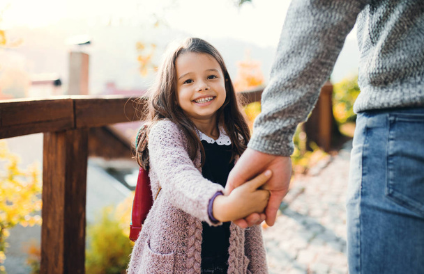 Malá dívka drží ruku k nepoznání otce na procházce na podzim. - Fotografie, Obrázek