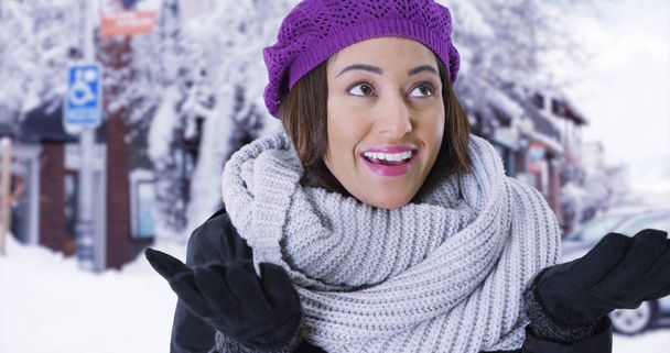 Retrato de la alegre latina de pie en la ciudad nevada sonriendo a la cámara
 - Foto, Imagen