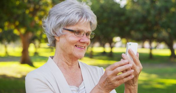 Hippe Oma macht Selfies im Park - Foto, Bild
