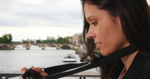 Joven fotógrafo de viajes en París tomando fotos mientras está en el puente sobre el Sena
 - Foto, Imagen