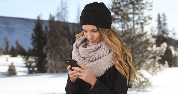 Tyttö juo kahvia tai teetä ulkona lumessa ja nauraa viesti
 - Valokuva, kuva
