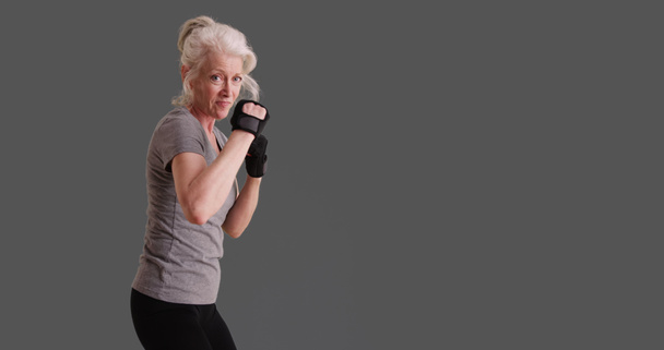 Sportos nő ő 50-es években feltett harcművészeti irányvonala a szürke háttér - Fotó, kép