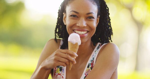 Black woman smiling and eating ice cream - Foto, Bild