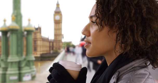 Westminster Köprüsü üzerinde duran ve kahve yudumlarken oldukça siyah erkek closeup - Fotoğraf, Görsel