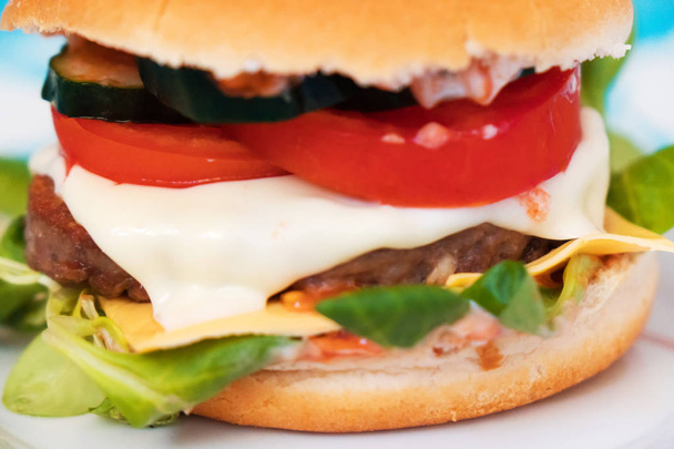 Domácí hamburger s hovězím masem, strouhaným sýrem a rajčaty. - Fotografie, Obrázek