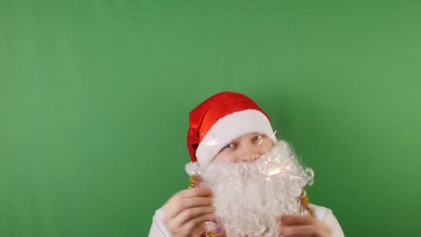 Happy man like a Santa Claus with sparklers, christmas and New year 2019, on green Chroma key - Záběry, video