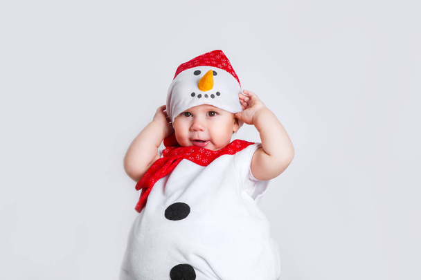 Merry Christmas and Happy New Year. Happy baby girl in snowman costume on white background - Фото, изображение