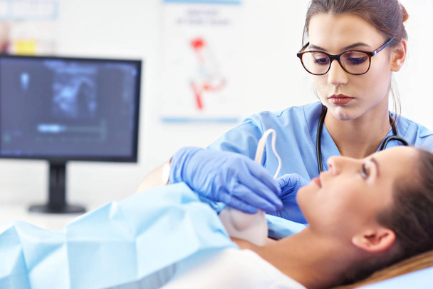 Adult woman having thyroind ultrasound test at female doctors office - Фото, зображення