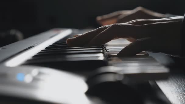 Bliska palców pianisty, naciskając klawisze syntezator. Ręce człowieka gra solo muzyki syntezator. Zwolnionym tempie Side Zobacz strzał na białym tle - Materiał filmowy, wideo