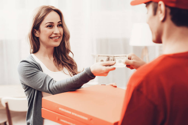Pizza Delivery. Pizza Deliveryman. Man with Box is Accessory. White Interior. Deliveryman Arab Nationality. Courier in Orange Clothes. Woman with Courier. Express Delivery. Pizza Delivery Payment. - Photo, Image