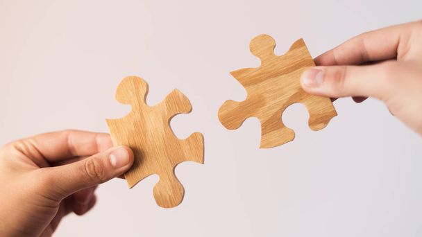 İki el çift ahşap bağlanmaya çalışıyor parça puzzle. Dernek ve bağlantısı, iş stratejisi kavramı. - Fotoğraf, Görsel