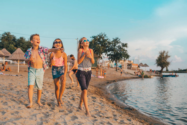 Porträt glücklicher Kinder beim Spazierengehen am Ufer - Foto, Bild