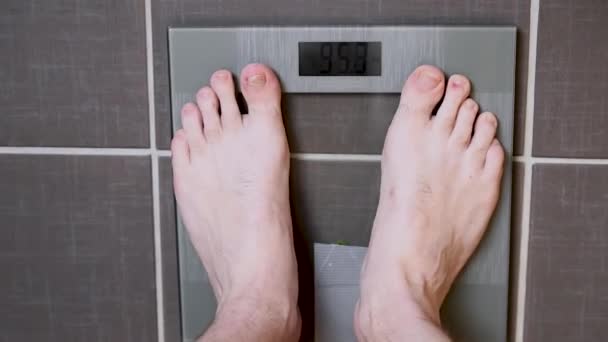 Piedi maschili su bilance di vetro, dieta da uomo, peso corporeo
 - Filmati, video