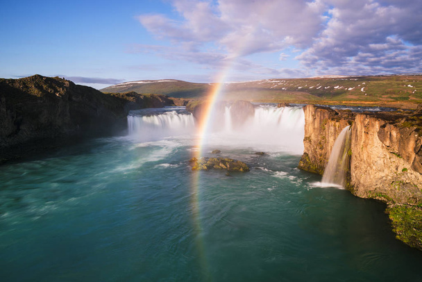 Годафосс - один из исландских водопадов. Известный туристический аттракцион. Летний пейзаж с радугой в солнечную погоду
 - Фото, изображение