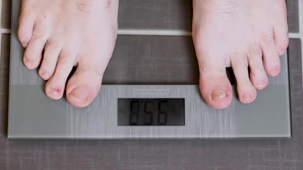 Piedi maschili su bilance di vetro, dieta da uomo, peso corporeo
 - Filmati, video