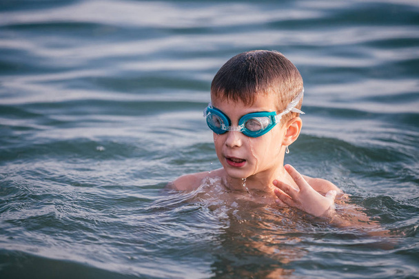 glückliches Kind beim Spielen und Schwimmen im Meer mit Schwimmbrille. Sommerferienkonzept - Foto, Bild