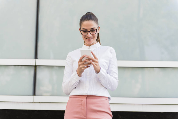Portrait of young businesswoman using mobile phone on a break at outdoor - Fotoğraf, Görsel