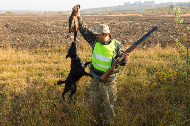 Hunters with a german drathaar and spaniel, pigeon hunting with dogs in reflective vests - Photo, Image