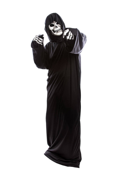 Halloween costume of a skeleton grim reaper wearing a black robe on a white background pointing forward - Valokuva, kuva