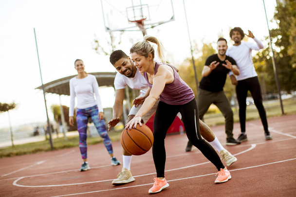 Group of multiracial young people   playing basketball  on court at outdoors - Photo, Image