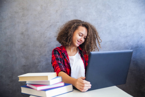 Göndör hajú tini lány dolgozik laptop portréja - Fotó, kép