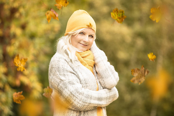 Portrait of beautiful senior woman in autumn park. - 写真・画像