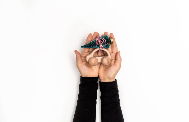 Mão segurando um carro de brinquedo em miniatura com uma árvore
 - Foto, Imagem
