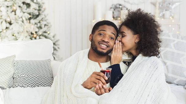 Giovane ragazza nera sussurrando al suo uomo sorridente
 - Foto, immagini