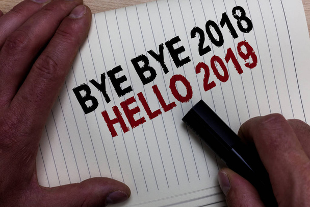 Texto de escritura de palabras Bye Bye 2018 Hello 2019 Concepto de negocio para comenzar el nuevo año El mensaje motivacional 2018 ha terminado La mano de Mans agarra el marcador negro con algunos textos en blanco y negro
. - Foto, Imagen