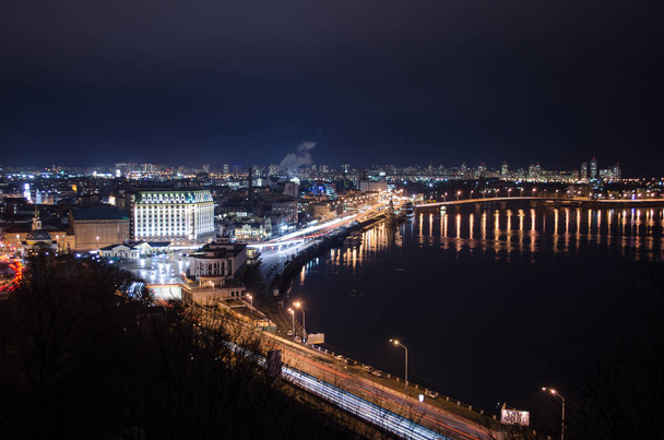 Panorama of night city landscape with river and bridge. Reflection of glowing lanterns in water - Φωτογραφία, εικόνα