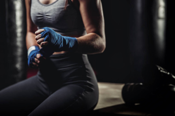 Mulher envolve seus punhos em ligaduras rosa para luvas de boxe
 - Foto, Imagem