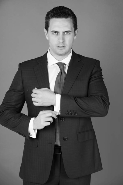 man in elegant formal suit and tie fixing cufflinks - Foto, immagini