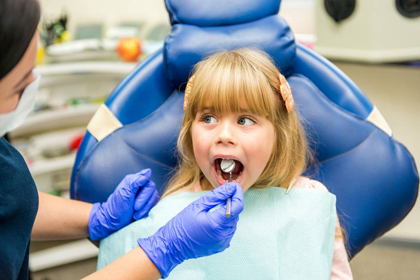 Μικρό κορίτσι sitts στο γραφείο οδοντιάτρων - Φωτογραφία, εικόνα