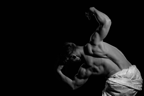 Man with muscular body in white fascia. - 写真・画像