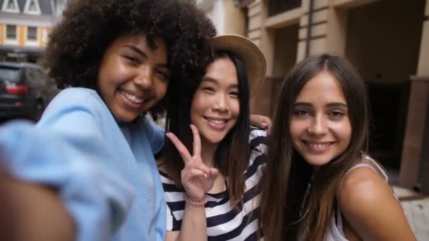 Wesoły multi etniczne dziewczyny biorąc selfie na zewnątrz - Materiał filmowy, wideo