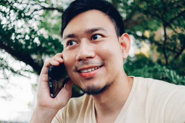 Happy Asian man has a conversation on smartphone. - Фото, зображення
