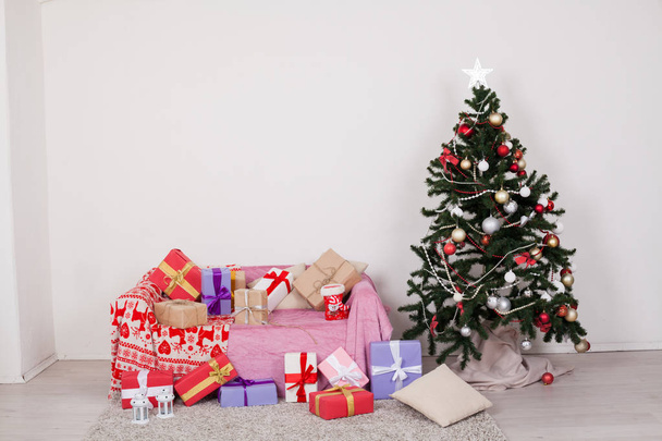 Arbre de Noël dans une pièce blanche avec décorations de Noël et jouets cadeaux
 - Photo, image